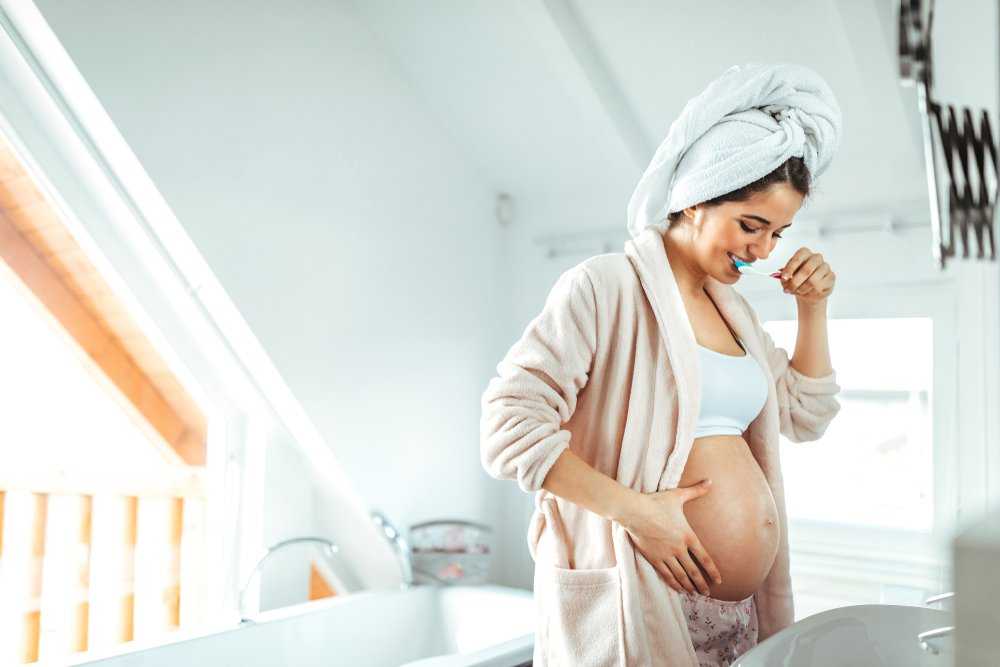 Беременная девушка светит большими сосками во время водных процедур